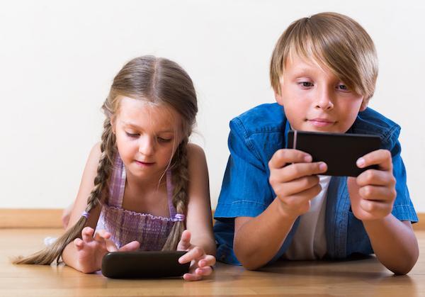 Two children playing with cell phones